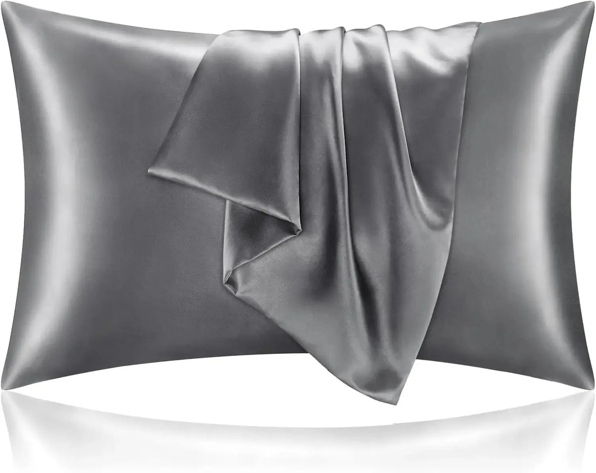 A pair of satin pillowcases on a made bed, showing the sheen of the fabric