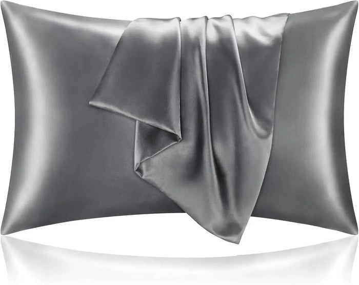 A pair of satin pillowcases on a made bed, showing the sheen of the fabric
